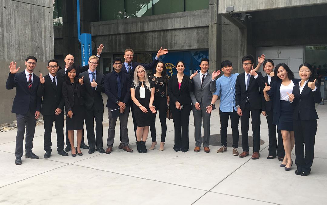 Business students in suits gather together on campus.